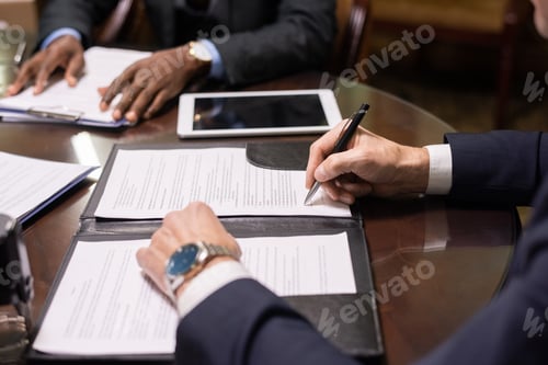 Preview: Hands of mature lawyer signing contract or other document