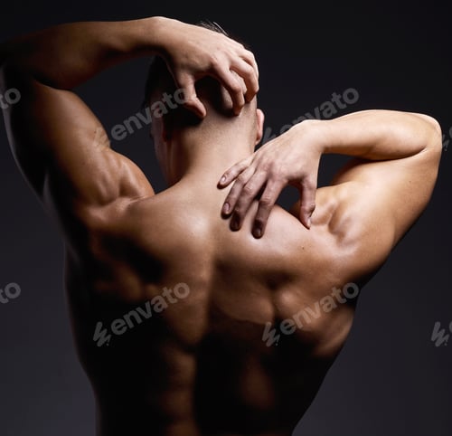 Preview: Shot of a muscular young man posing against a black background