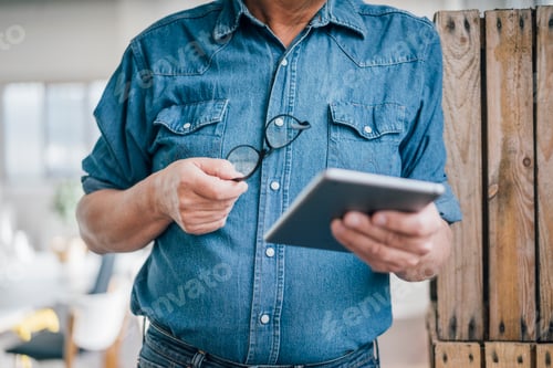 Preview: Close-up of businessman holding tablet in office