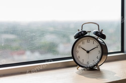Preview: Vintage alarm clock at windows at morning