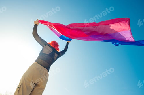 Preview: Beautiful low angle shot of a female waving red and blue flag