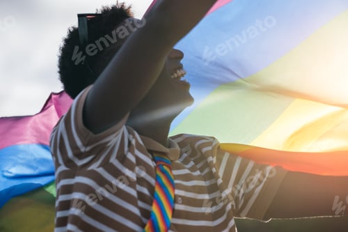 Preview: Unrecognizable young man carrying an LGBTI flag
