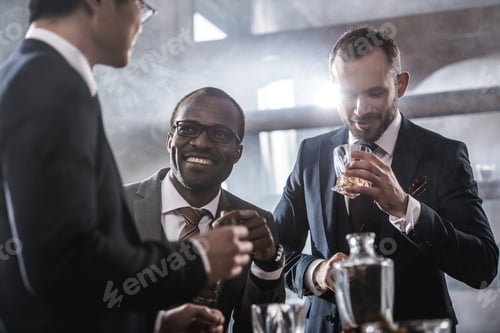 Preview: Multiethnic group of businessmen spending time together drinking whiskey and smoking, multicultural