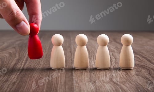 Preview: Hand placing a red human figurines next to other beige figurines