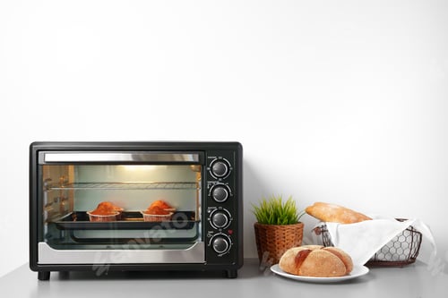 Preview: Electric mini oven and baked hot muffins close up