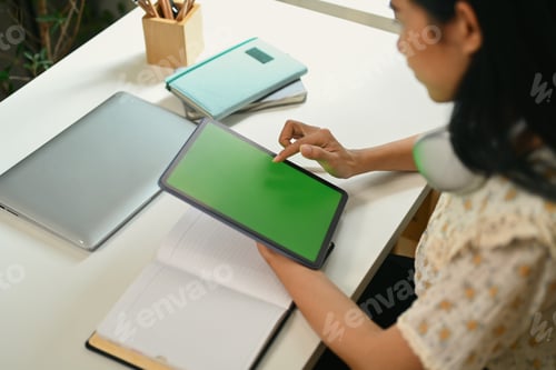 Preview: Cropped shot of woman reading social media posts on digital tablet.