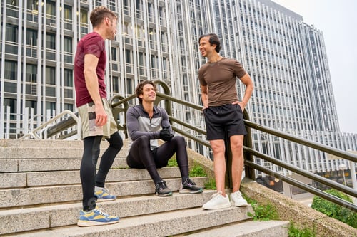 Preview: Sportsmen talking and resting on stairs in the city