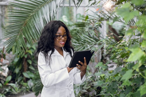 Woman in White Lab Coat Using Tablet