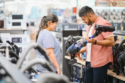 Preview: A young Indian couple buys a vacuum cleaner at an electronics store
