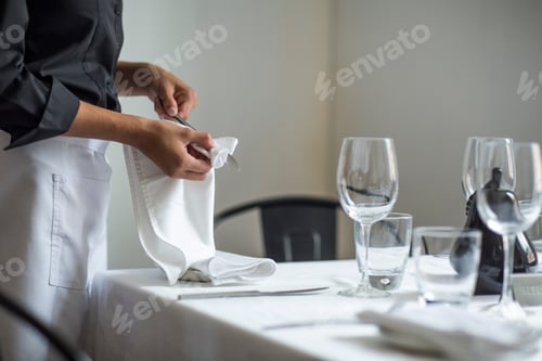 Preview: Waitress setting table in restaurant