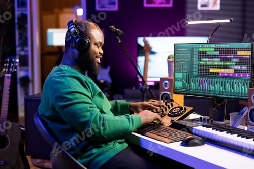 Preview: Confident music engineer working on mixing console in home studio