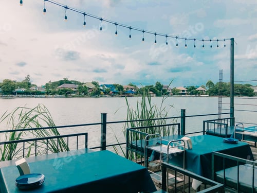 Preview: Lakefront Cafe With Tables, Chairs and String Lights