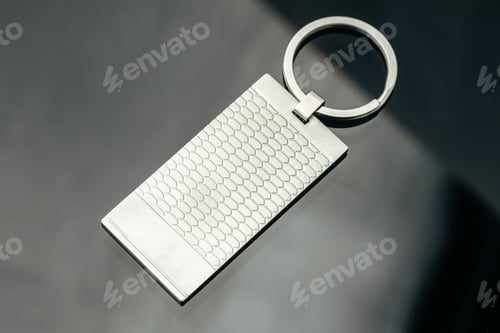 Preview: Stylish masculine metal key charm on black glass background