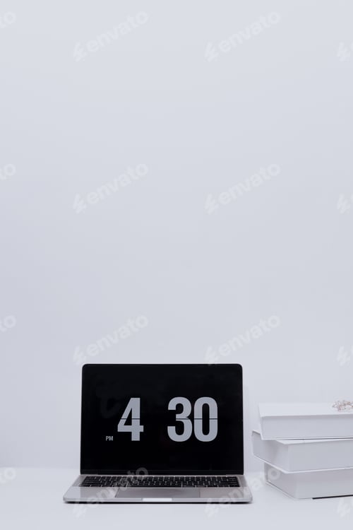 Preview: Laptop and stack of books on white office table