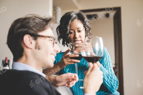 Preview: Young handsome mixed race couple in their house having a glass of red wine