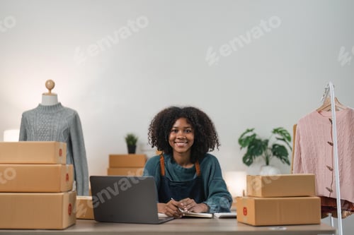 Preview: Entrepreneur, small business, SME, freelance woman working from home with lots of boxes on the side