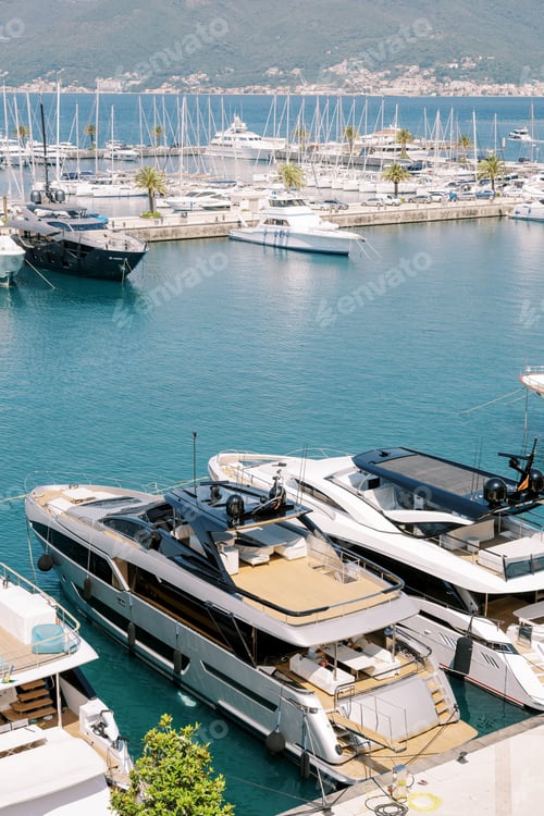 Preview: Double-deck motor yachts moored to the pier of a luxury marina
