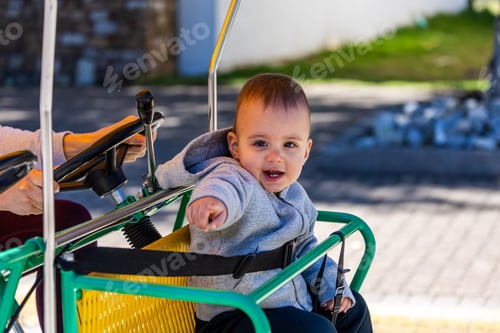 Preview: Adorable Baby Enjoying a Fun Bicycle Ride Outdoors on a Sunny Day with Family