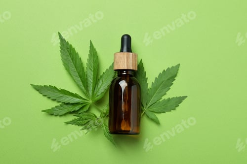 Preview: Cannabis oil and leaves on green background