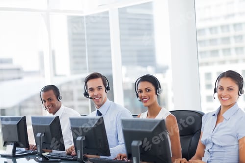 Preview: Line Of Call Centre Employees Smiling And Working On Computers