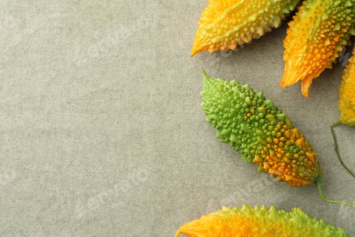 Preview: Many fresh bitter melons on grey cloth, flat lay. Space for text