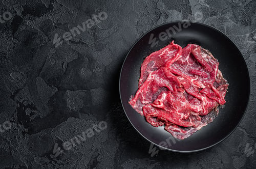 Preview: Marbled beef meat carpaccio. Black background. Top view. Copy space