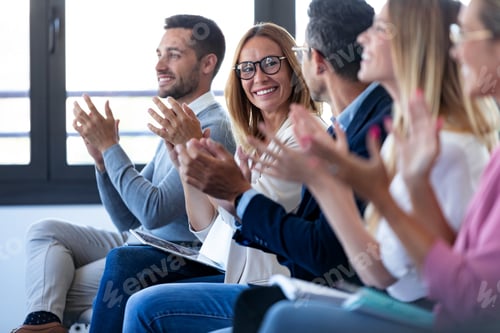 Preview: Happy business team clapping after listening the conference while sitting on coworking space.