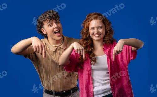 Preview: Young Couple Bloggers Pointing Down To Advertising Area. Click Subscribe Below