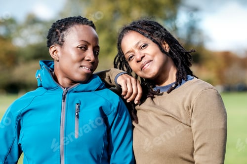 Preview: Two mature women friends posing together in a park in autumn.