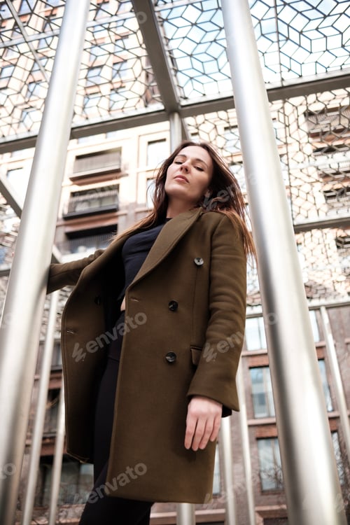 Preview: Caucasian woman grabbing a metal tube from structure in street.