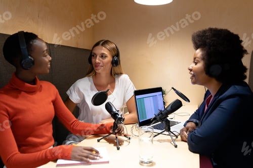 Preview: Diverse group of happy female business colleagues wearing headphones, speaking to microphones