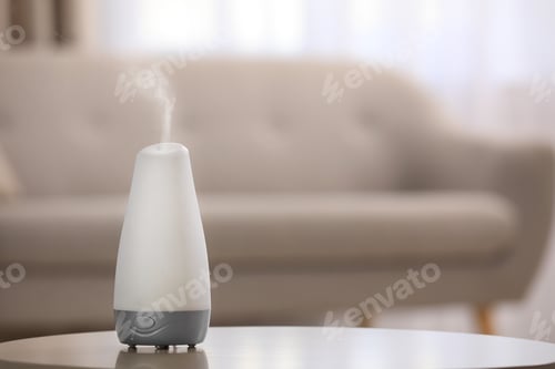 Preview: Modern essential oil diffuser on table indoors. Space for text
