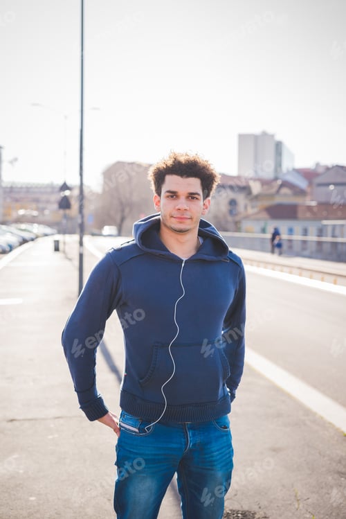 Preview: young man standing in the street and looking camera