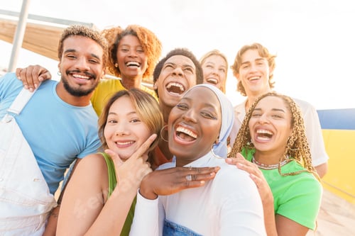 Preview: African woman taking selfie with multi-ethnic friends outdoors