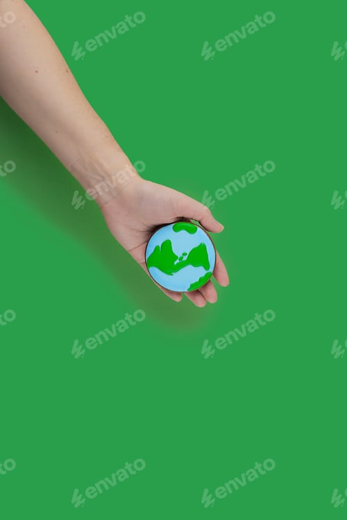 Preview: Earth Day concept. Сookie in shape of Earth in hand.