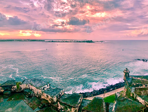 Preview: Silhouette over ocean waters during Golden hour pink sunset with storm clouds In the background