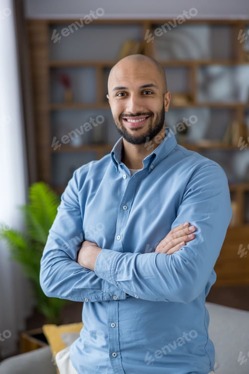Preview: Young man smiling with crossed arms radiating confidence