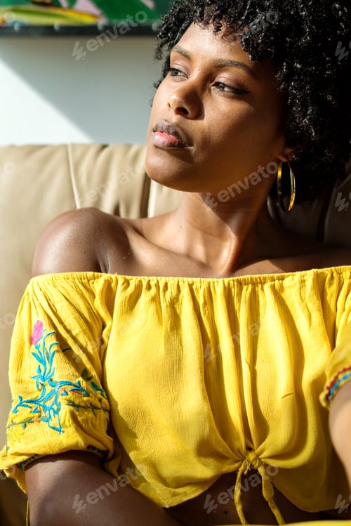 Preview: Black woman relaxing on the coach at home