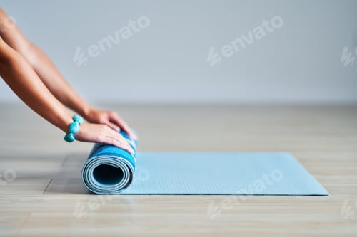 Preview: Woman Rolling Up Blue Yoga Mat on Floor