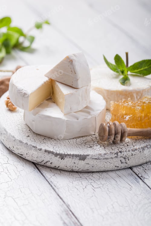 Preview: Camembert cheese on a wooden board with nuts, honey and mint. Italian, French gourment