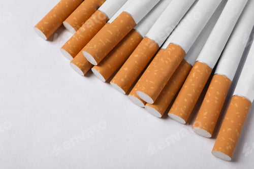 Preview: Pile of cigarettes with orange filters on white background, above view. Space for text