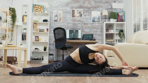 Preview: Flexible young woman standing in slip on yoga mat