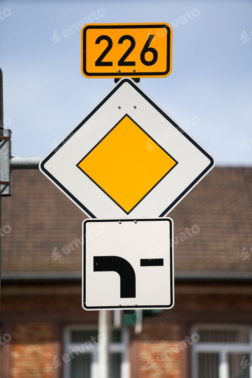 Preview: "main road" yellow street sign on the road, close-up, vertical