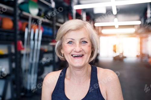 Preview: Portrait of happy senior woman in gym