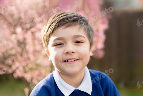 Preview: happy young boy looking at camera with smiling face, School kid standing in the front garden