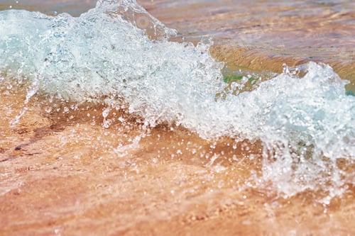 Preview: Sea wave on the sand beach, soft focus. Summer background