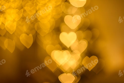 Preview: A lot of golden lights in the shape of hearts in the defocus on a dark background
