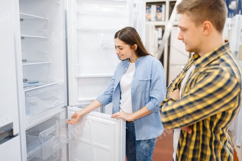 Preview: Couple choosing refrigerator in electronics store