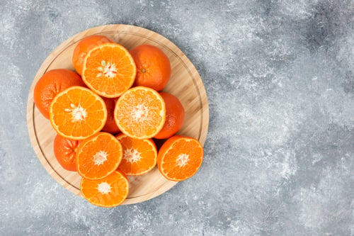Preview: Sliced juicy fresh orange fruits in a wooden plate
