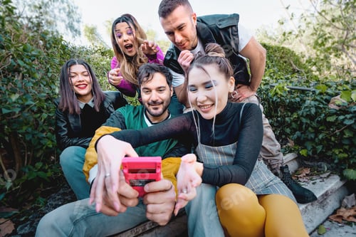 Preview: Group of Friends Enjoying Retro Gaming Device Outdoors